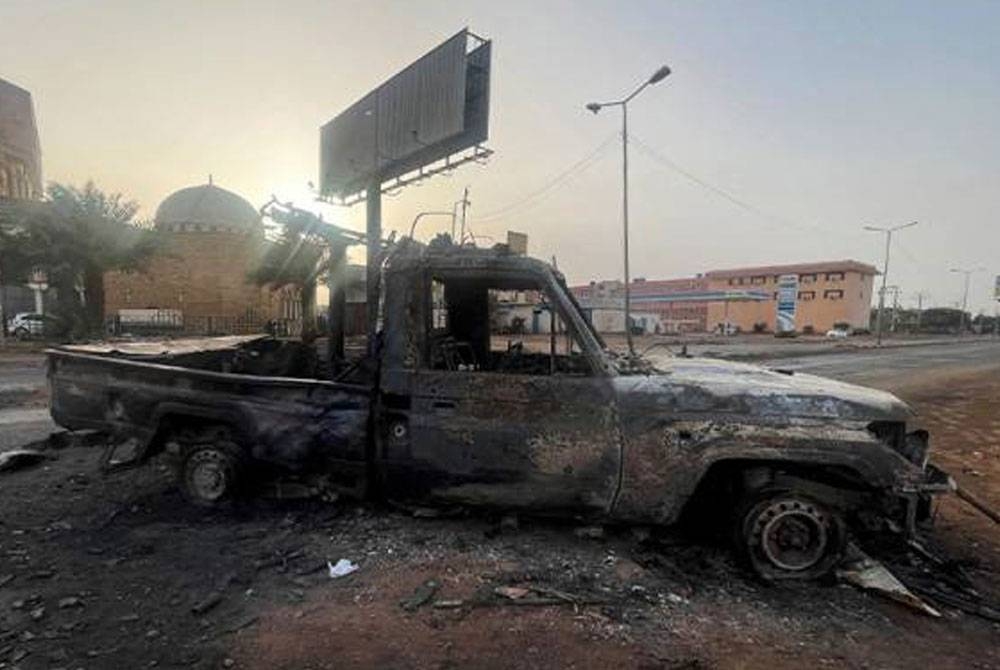 Sebuah kereta dilihat terbakar di Khartoum, Sudan. - Foto Reuters