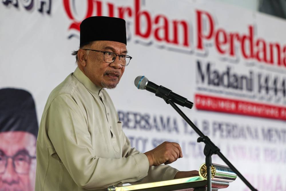 Anwar menyampaikan ucapan perasmian pada program Korban Perdana Madani 1444H di kawasan perniagaan Arowana Permatang Pauh hari ini. - Foto Bernama