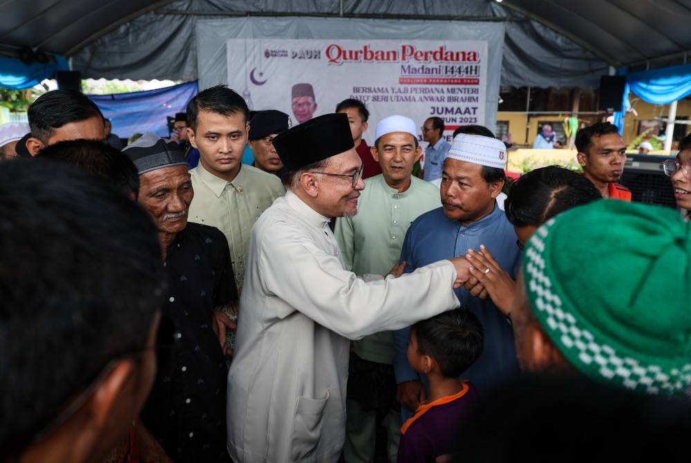 Anwar bersalaman dengan orang ramai pada Majlis Korban Perdana Madani 1444H Parlimen Permatang Pauh di Masjid Sama Gagah hari ini. - Foto Bernama