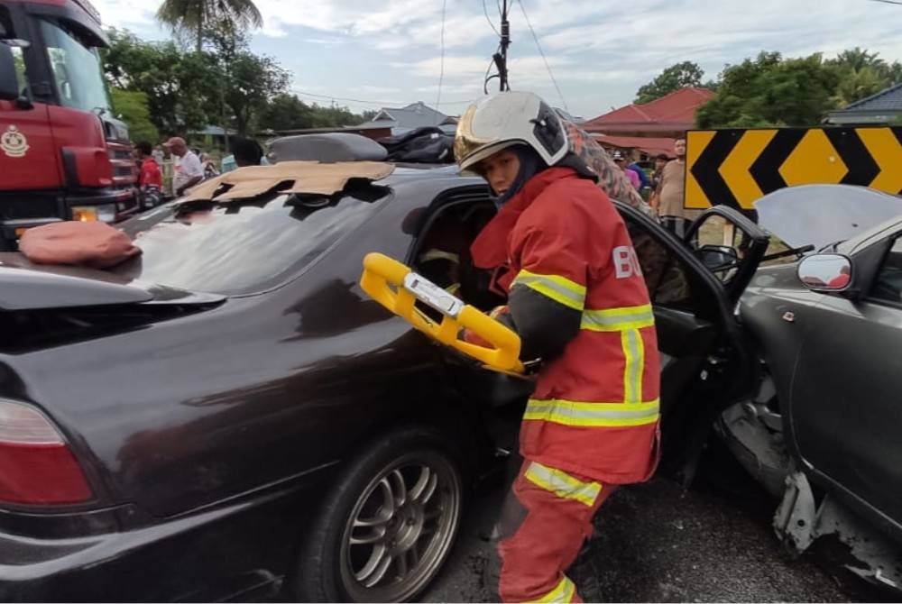 Anggota bomba mengeluarkan mangsa kemalangan di Jalan Iskandar menghala ke Kampug Bukit Kapar, di sini, pada Ahad.