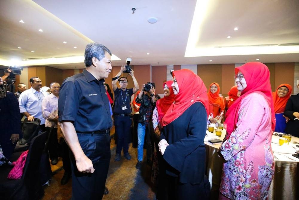 Mohamad berbual dengan Ketua Wanita UMNO Pulau Pinang, Datuk Norliza Abdul Rahim ketika mengadakan pertemuan secara tertutup dengan pimpinan UMNO Pulau Pinang pada Isnin.