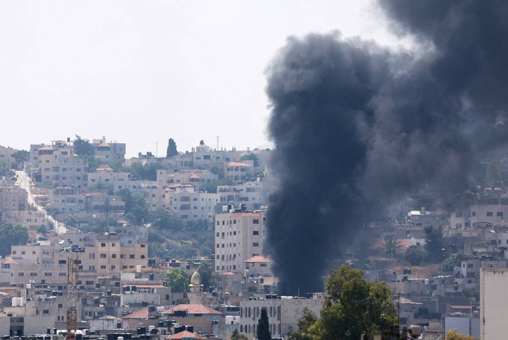 Asap tebal memenuhi ruang udara di bandar Jenin yang dibedil bertalu-talu rejim Zionis pada Isnin. - Foto AFP