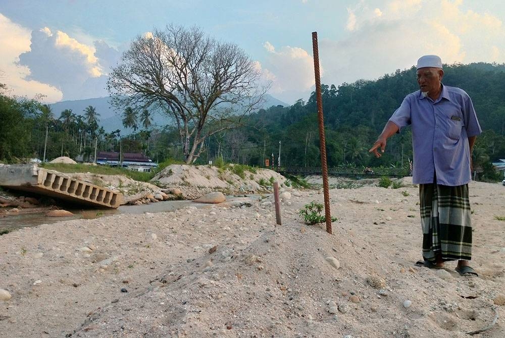 Ahmad menunjukkan tapak asal rumahnya yang hanyut dibawa arus dalam tragedi banjir aliran puing Kampung Iboi Julai tahun lalu, kini hanya tinggal tanah lapang.