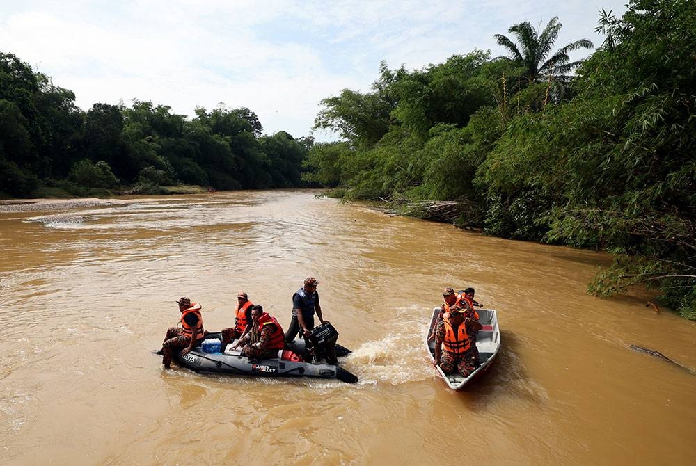 Pasukan penyelamat melakukan operasi mencari mangsa yang terlibat dalam kejadian kepala air di Jeram Air Putih ketika tinjauan di Kampung Teladas pada Isnin. - Foto Bernama