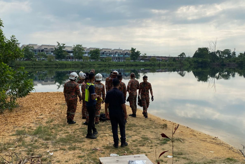 Pasukan penyelamat membantu mengeluarkan mayat mangsa yang ditemui terapung di dalam sebuah lombong di Taman Rasi Jaya, Menglembu di sini pada Selasa.