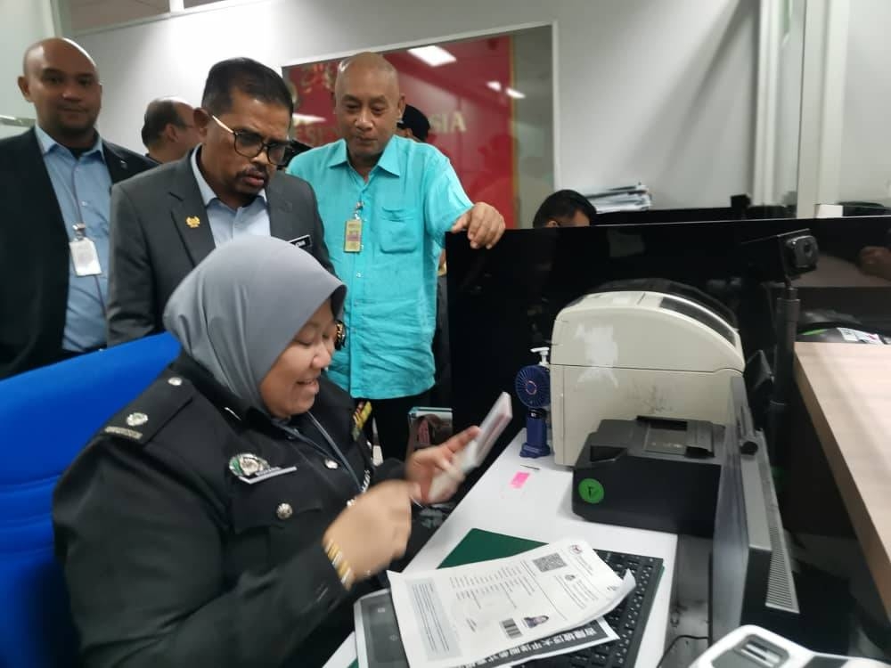 Adnan (dua dari kiri) meninjau operasi petugas-petugas Jabatan Imigresen di KLIA 1 dalam lawatannya pada Selasa.