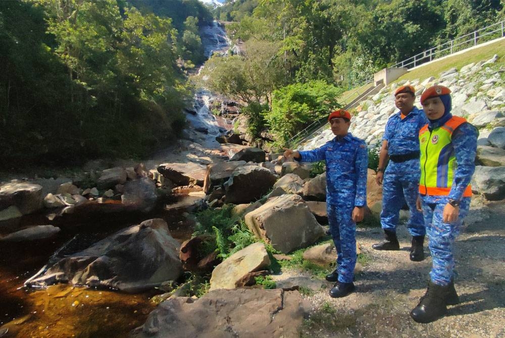 Timbalan Pengarah APM Kedah, Mejar (PA) Mohd Muaz Mohd Yusoff (kiri) bersama Pegawai Pertahanan Awam Daerah Yan, Leftenan (PA) Muhammad Zul Izzi Zulkifli (tengah) meninjau kawasan Air Terjun Seri Perigi pada Rabu.