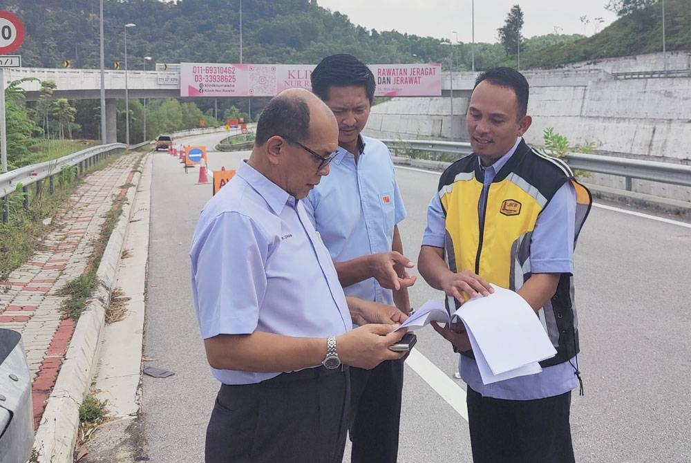 Izham (kiri) meninjau projek pembinaan lorong tambahan bagi menangani kesesakan di Jalan Persiaran Mokhtar Dahari di sini pada Rabu.