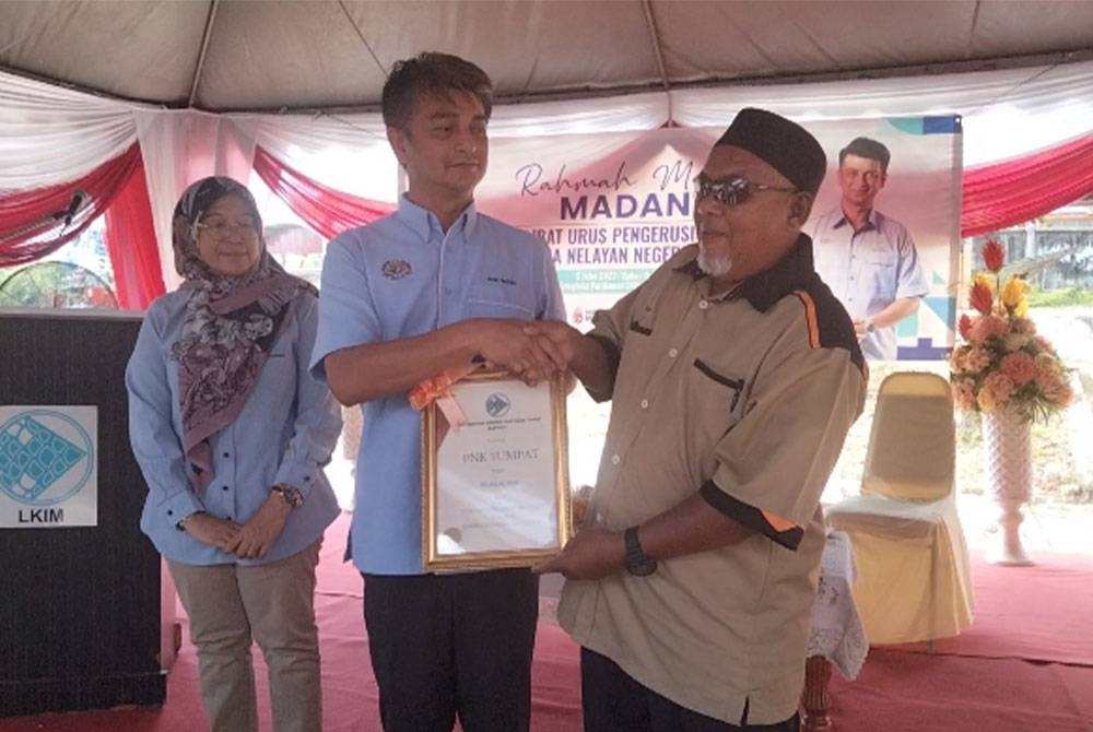 Muhammad Faiz menyampaikan sijil penghargaan kepada Hamid di Majlis Penyerahan Projek Siap Naik Taraf Slipway kepada Persatuan Nelayan Kawasan (PNK) Tumpat pada Rabu.