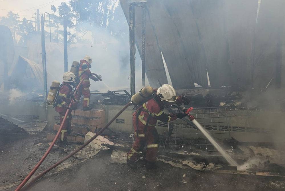 Anggota Bomba dan Penyelamat memadamkan kebakaran pejabat Jakoa Daerah Gombak dan Petaling di Kampung Sungai Chinchin, di sini, musnah dalam kebakaran, pada Rabu.