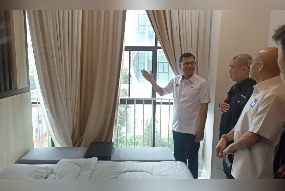 Akmal Nasrullah (kanan) meninjau rumah di Residensi Larkin Indah pada Khamis.