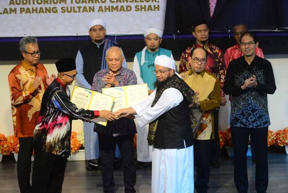 Mohd Soffi (tengah) menyaksikan pertukaran MOU yang akan ditandatangani oleh Mohd Zawavi (kiri) bersama salah satu agensi pada Majlis Perasmian Program Seso Jelajah Agensi Kelayakan Malaysia bersama Pemberi Pendidikan Tinggi (PPT), Zon Timur pada Khamis.