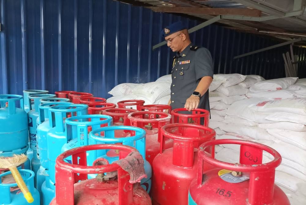 Penguat kuasa KPDN memeriksa LPG yang disimpan.