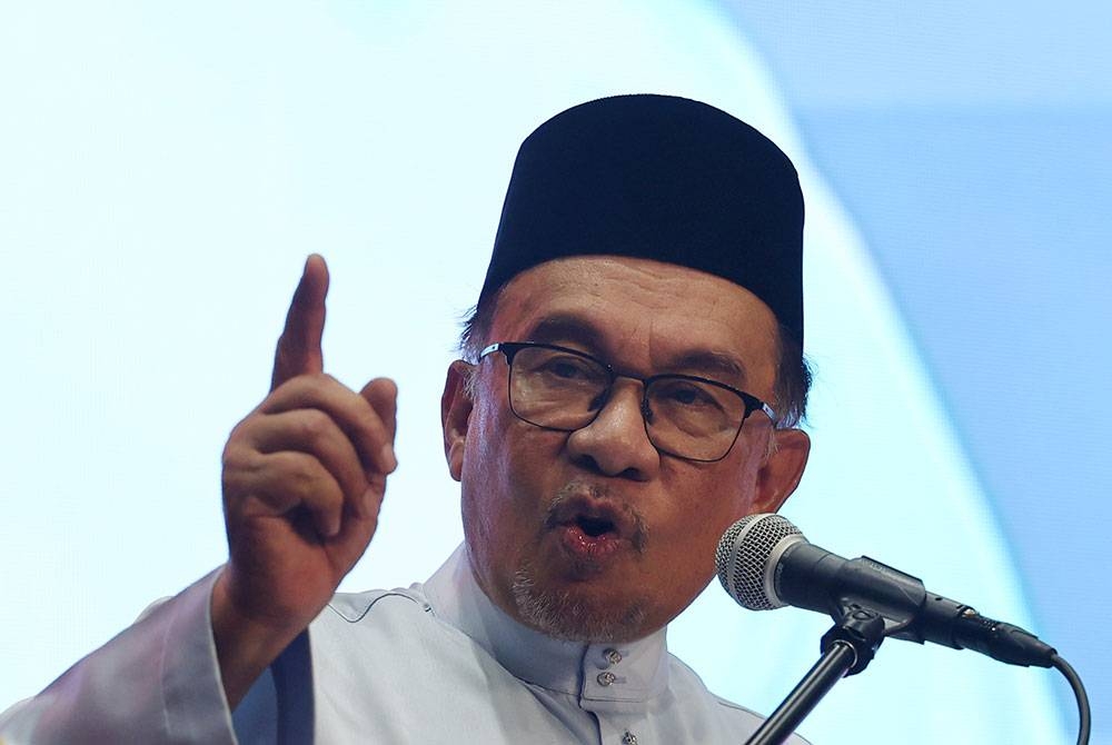 Perdana Menteri Datuk Seri Anwar Ibrahim (kiri) ketika berucap pada Majlis Sambutan Hari Peneroka Felda 2023 Peringkat Kebangsaan di Taman Ekspo Pertanian Malaysia (MAEPS) pada Jumaat. - Foto Bernama.