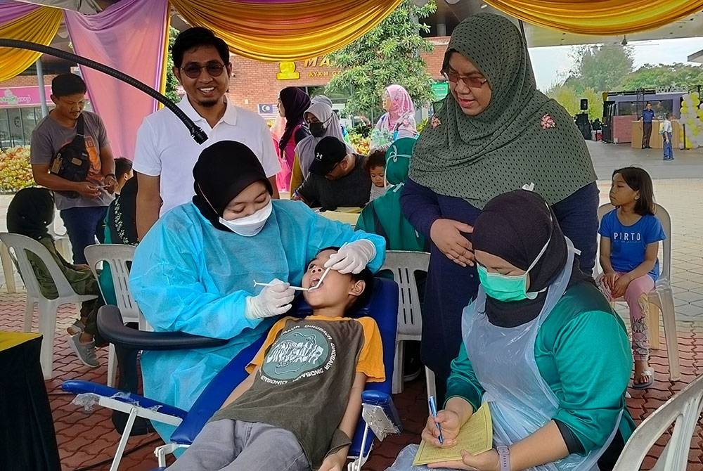 Dr Nor Azimi meninjau aktiviti pemeriksaan gigi sempena Sambutan Minggu Promosi Kesihatan Pergigian Peringkat Negeri Pahang di Kotasas pada Sabtu.