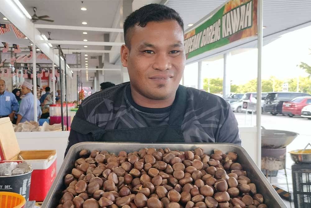 Muhammad Rizuan menunjukkan buah berangan yang dijualnya.