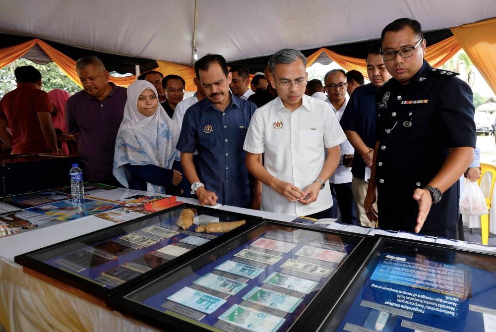 Fahmi (dua dari kanan) melawat bilik pameran pada Majlis Hari Bersama Komuniti Pusat Ekonomi Digital (PEDi) di Kampung Kanchong Darat, Banting, pada Ahad. - Foto Bernama