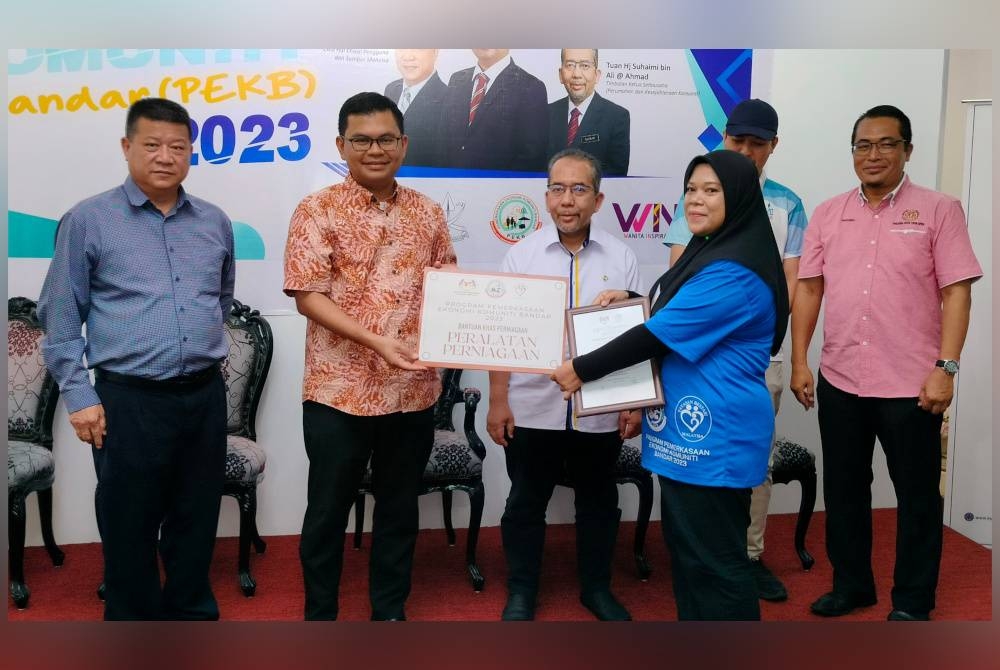 Akmal Nasrullah menyerahkan bantuan khas kepada salah seorang usahawan pada Majlis Perasmian Penutup Program PEKB 2023 di Teja Skill pada Ahad.