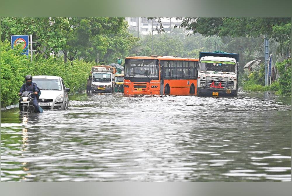 Kenderaan terkandas selepas hujan lebat di Delhi pada Sabtu. - Foto AFP