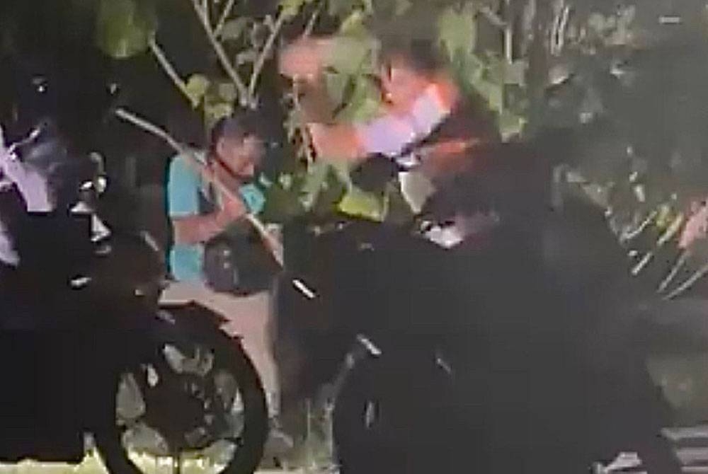 Tangkap layar klip video yang dimuat naik di Twitter yang memaparkan dua lelaki menyerang seekor anjing sehingga mati.