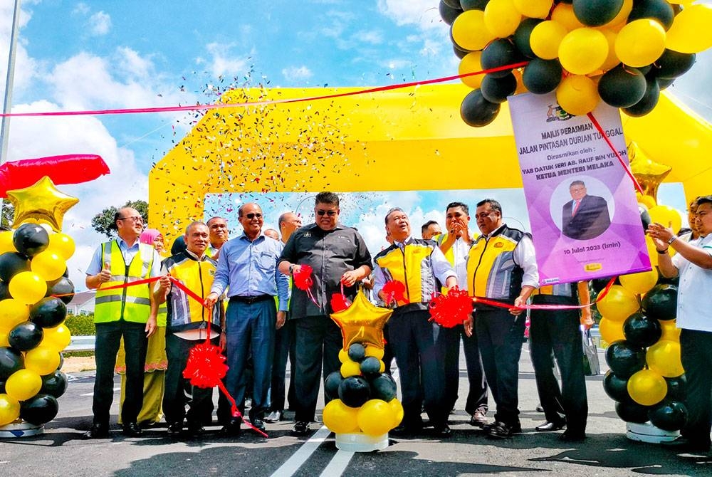 Alexander Nanta Linggi dan Ab Rauf (tengah) ketika perasmian jalan pintas baharu dari persimpangan Jalan Alor Gajah Lama (M17) ke Taman Murai Jaya, Alor Gajah pada Isnin.