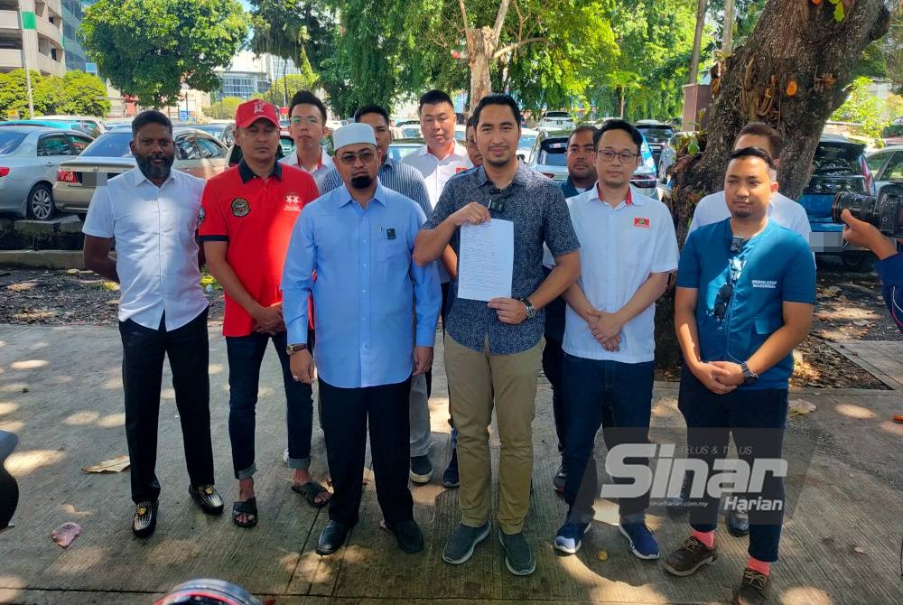 Wan Ahmad Fayhsal (tengah) menunjukkan laporan polis yang dibuat oleh Armada Wilayah dan disaksikan oleh parti komponen PN di IPD Dang Wangi pada Isnin.