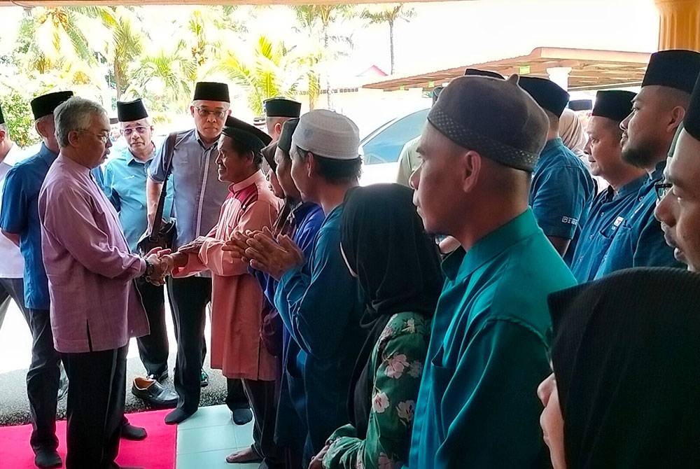 Al-Sultan Abdullah mencemar duli bersalaman dengan Eiyi yang merupakan bapa kepada sembilan beranak yang lemas dalam kejadian kepala air pada 1 Julai lalu