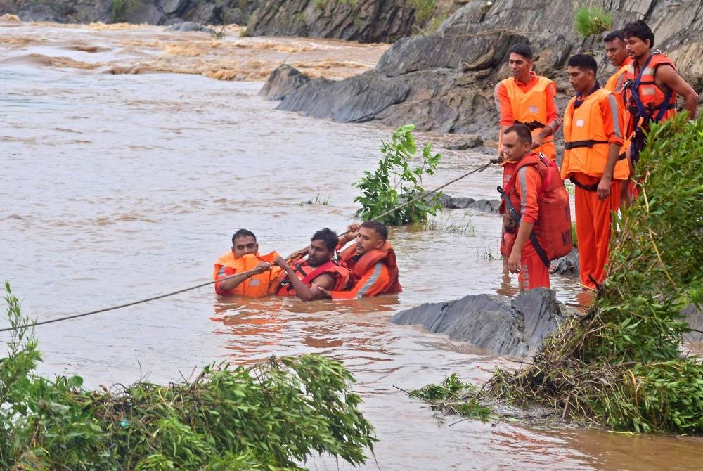 Pasukan Tindak Balas Bencana Kebangsaan (NDRF) India menyelamatkan nelayan dari sungai Narmada yang deras selepas hujan lebat di Jabalpur pada Isnin. - Foto AFP