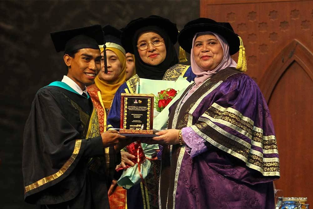 Rubiah (kanan) menyampaikan anugerah Menteri
Kemajuan Desa dan Wilayah kepada seorang graduan semasa Majlis Konvokesyen UCAM Kali ke-20 di Dewan Tuanku Canselor USIM, di sini pada Selasa.