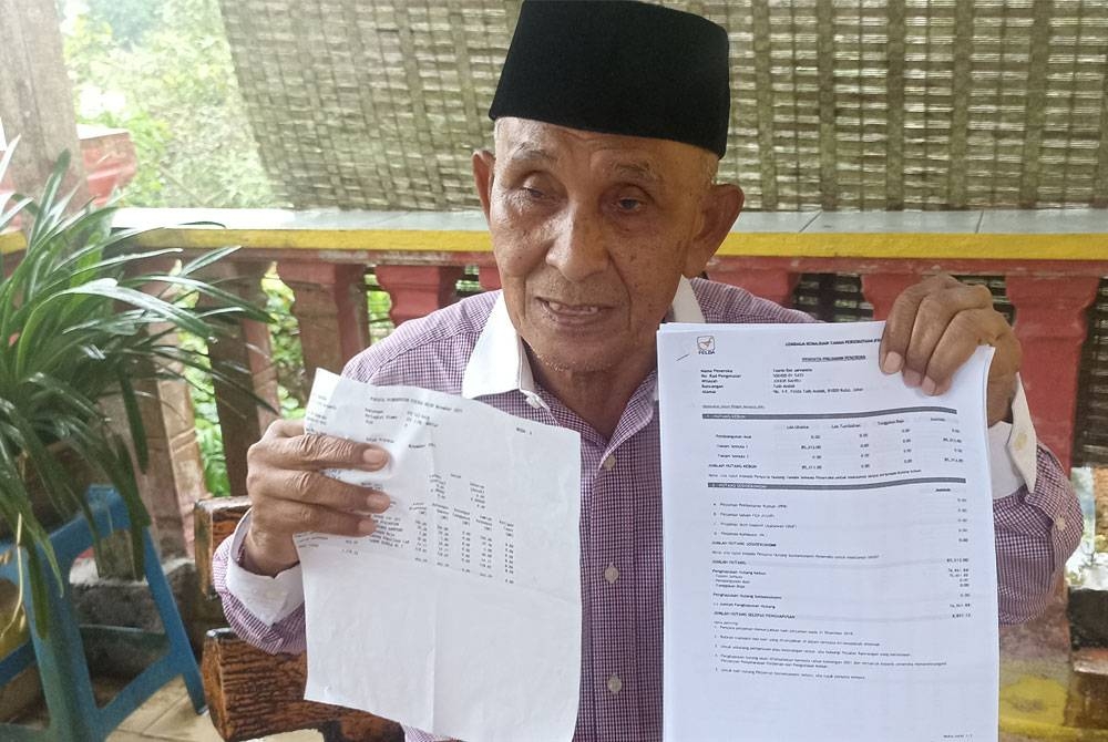 Tosrin menunjukkan penyata pinjaman peneroka miliknya yang menjadi bukti penghapusan hutang peneroka di Felda Taib Andak pada Selasa.