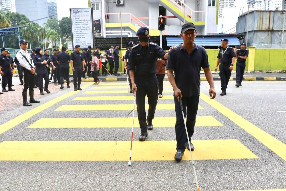 Mohd Shuhaily (kiri) merasai pengalaman sebagai OKU penglihatan dengan memakai penutup mata.