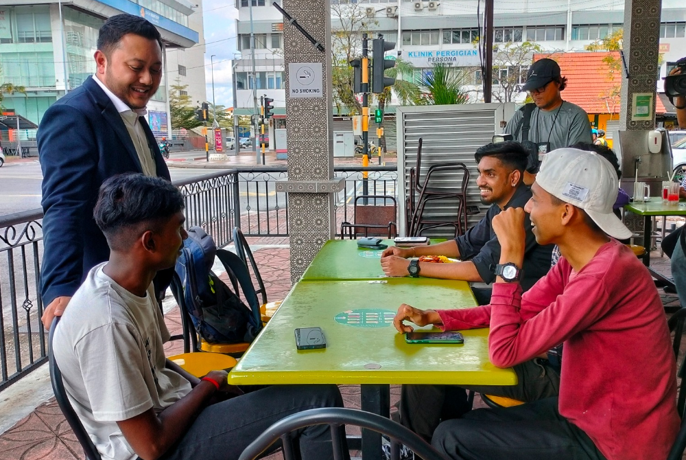 Ridhwan (kiri) ketika bertemu dengan kumpulan belia di Jalan Hang Tuah pada Rabu.