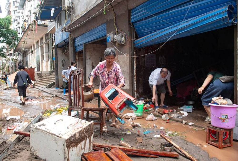 Penduduk mengemas rumah mereka yang dilanda banjir. - Foto Reuters