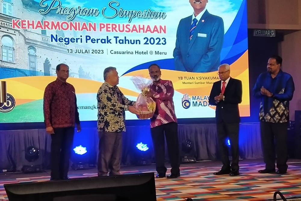 Sivakumar (dua dari kanan) menerima cenderahati daripada Khalid selepas merasmikan Program Simposium Keharmonian Perusahaan Negeri Perak Tahun 2023 di sebuah hotel pada Khamis.