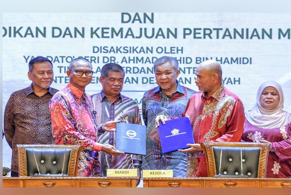 Ahmad Zahid dan Mohamad menyaksikan majlis pertukaran memorandum persefahaman antara Kejora dan MARDI bagi kerjasama strategik melalui program pembangunan pertanian dan pembangunan usahawan di KKDW hari ini. - Foto Bernama