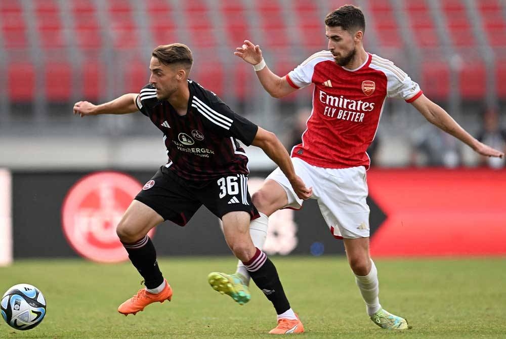 Penyerang Nurnberg, Lukas Schleimer (kiri) dan pemain tengah Arsenal, Jorginho bersaing merebut bola ketika aksi pra musim pada Jumaat. -Foto: AFP