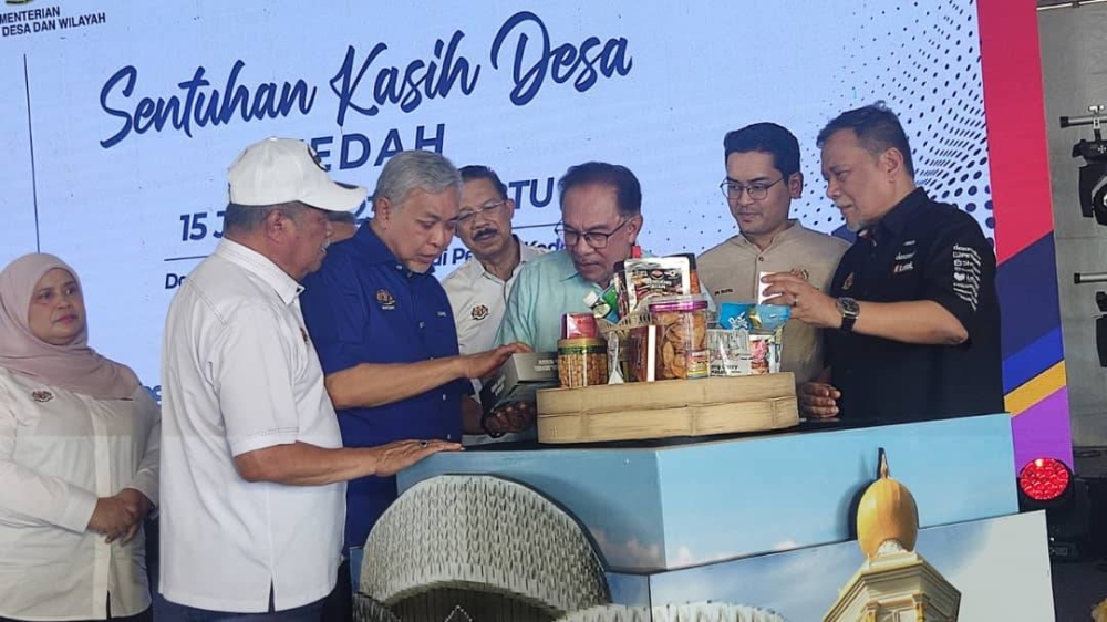 Anwar melihat produk yang dihasilkan oleh usahawan desa selepas melancarkan Program Mini Karnival Usahawan Desa di Dataran Amanjaya di Sungai Petani pada Sabtu.