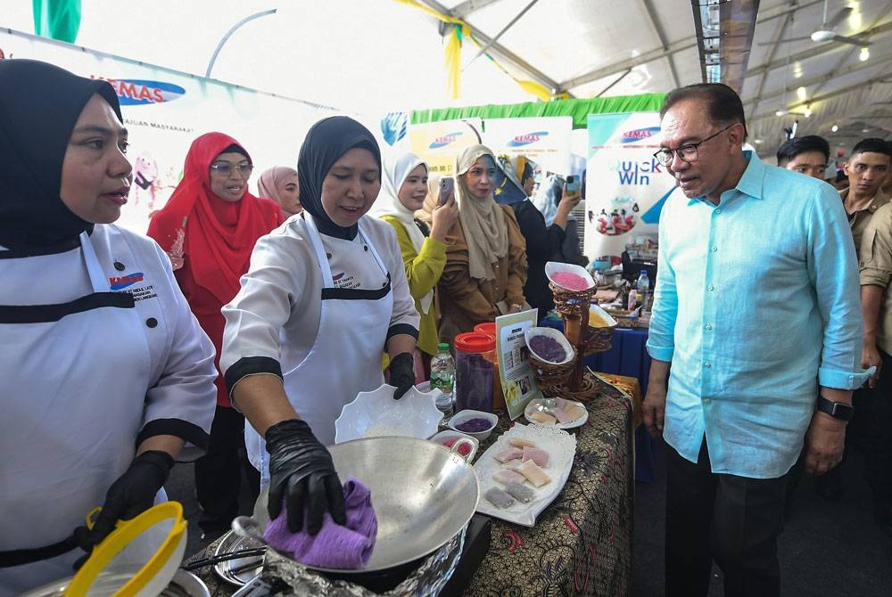 Anwar beramah mesra bersama para usahawan ketika melawat reruai pameran dan jualan pada perasmian Mini Karnival Usahawan Desa di Dataran Amanjaya Mall pada Sabtu. - Foto: Bernama