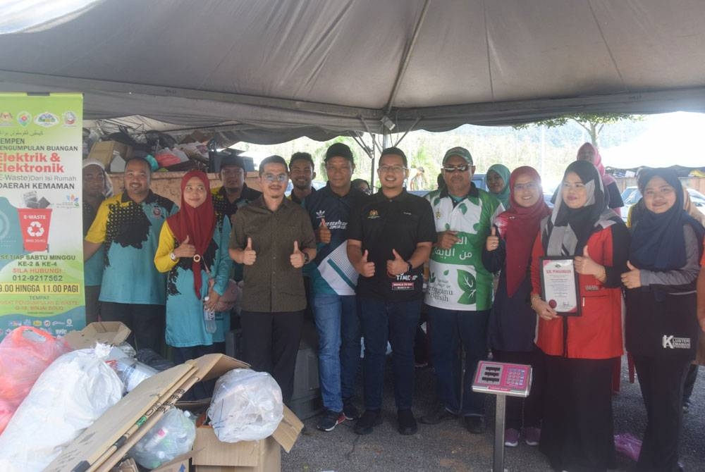 Nazwawi (lima dari kiri) sempena perasmian penutup program kempen Kitar Semula Bersama Komuniti Taman Bandar Baru Kijal melalui Program Pandu Lalu Jualan Barangan E-Sisa dan Kitar Semula di tempat letak kereta Sabasun Hyperuncit, Kijal di sini pada Sabtu.