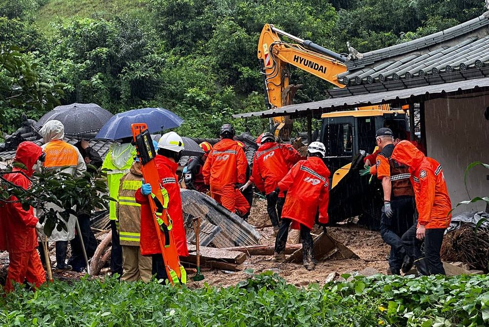 Anggota penyelamat mencari mangsa tanah runtuh di Yeongju. - AFP