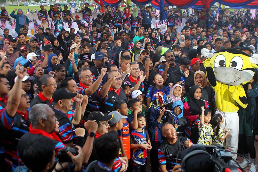 Fahmi (tengah) bergambar bersama para peserta Program 6,600 Langkah Perpaduan sempena Pelancaran Bulan Kebangsaan dan Kibar Jalur Gemilang 2023 yang berlangsung di Bulatan Sultan Azlan Shah, Meru Raya pada Ahad. - Foto Bernama