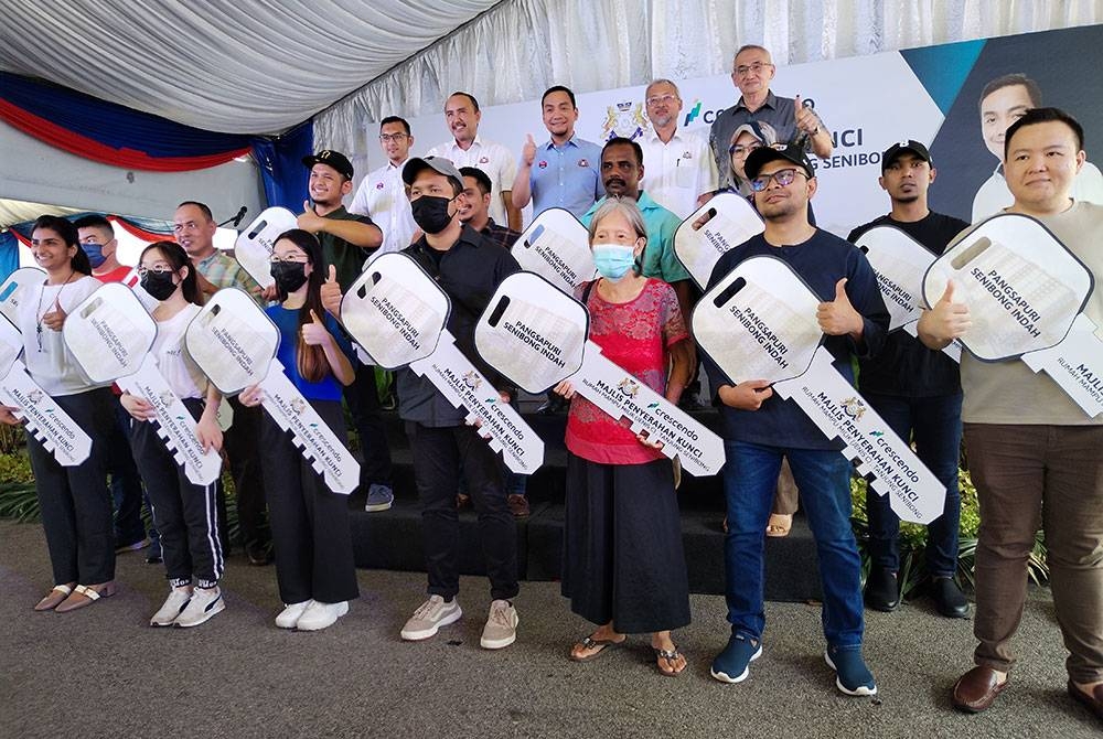 Onn Hafiz (belakang, tengah)bersama 15 penerima kunci Pangsapuri Senibong Indah, Tanjung Senibong, Masai pada Ahad.