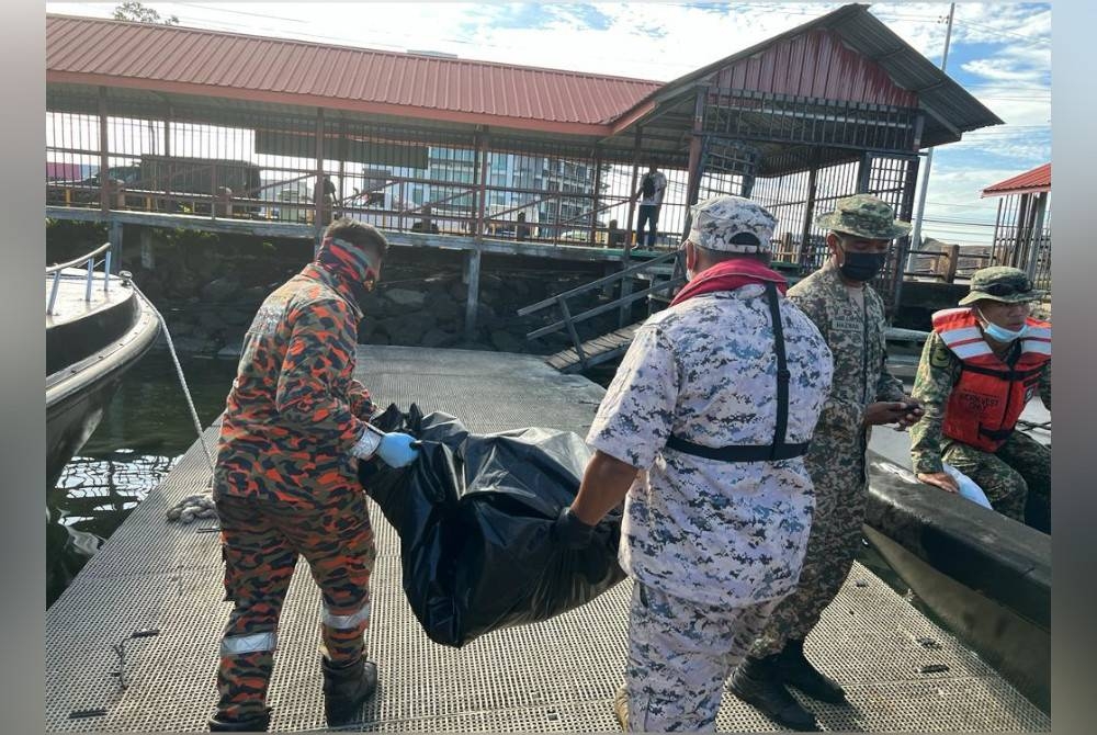 Pasukan SAR membawa mayat mangsa ke jeti untuk diserahkan kepada polis.