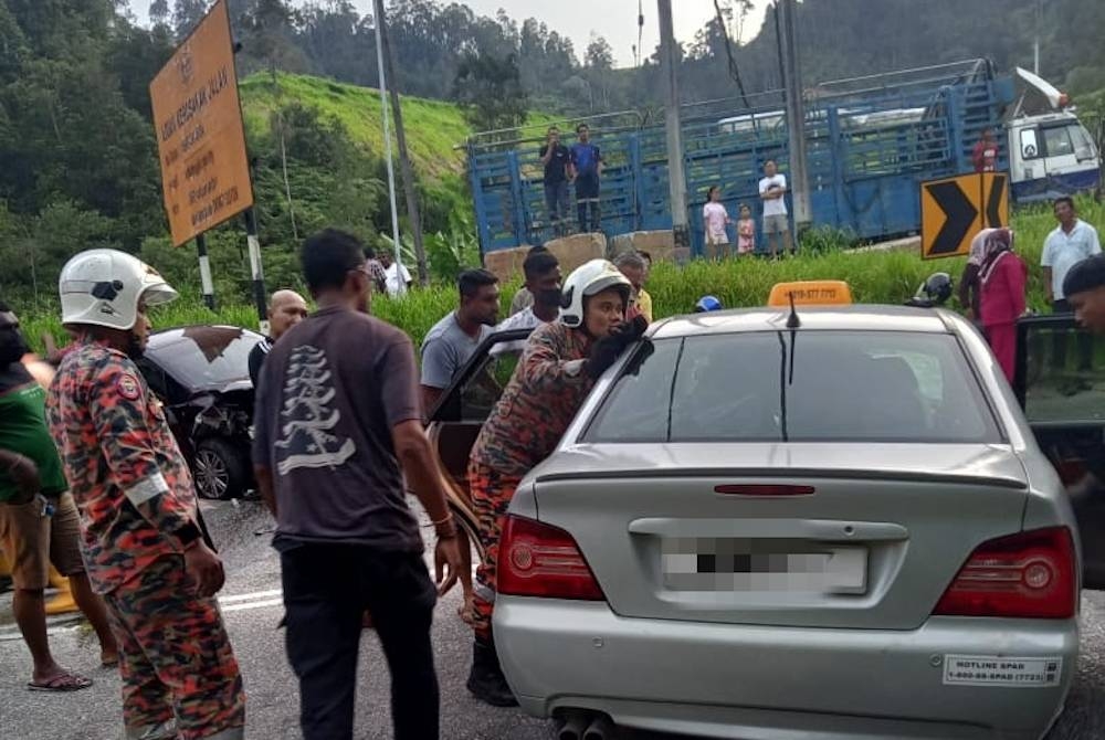 Anggota BBP Ringlet membantu keluarkan mayat mangsa dari kenderaan dinaiki selepas terbabit kemalangan libat tiga kenderaan di Jalan Ringlet, Cameron Highlands pada petang Ahad.