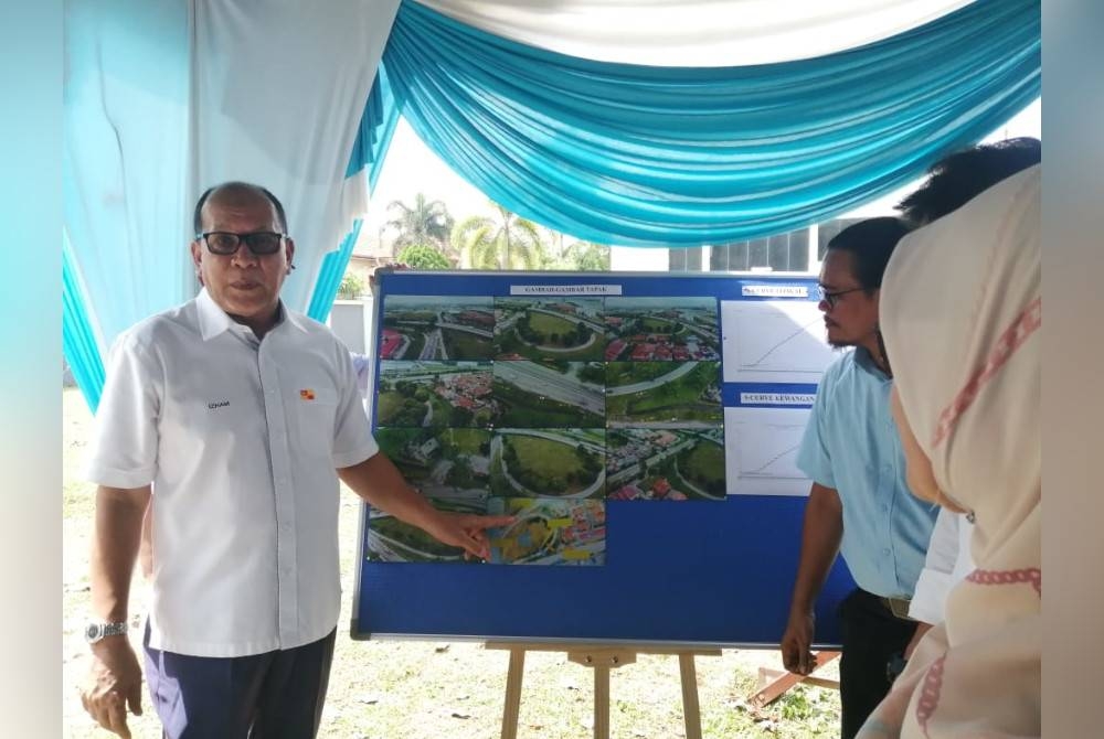 Izham (kiri) pada sesi taklimat Kolam Takungan di Taman Mutiara Bukit Raja, di sini pada Isnin.