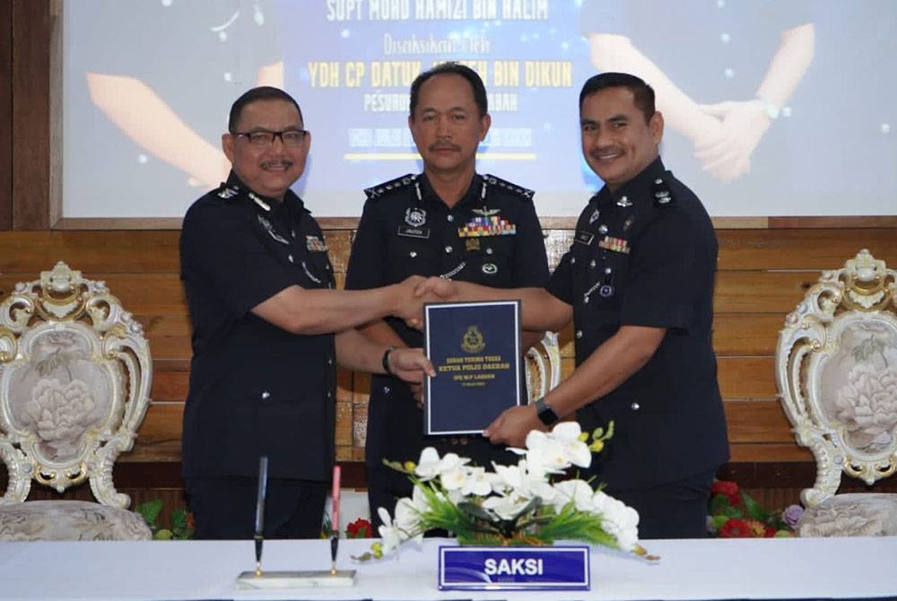 Jauteh (tengah) menyaksikan majlis serah terima tugas antara Ahmad (kiri) kepada Mohd Hamizi (kanan) di Dewan Bancolasi IPD Labuan.