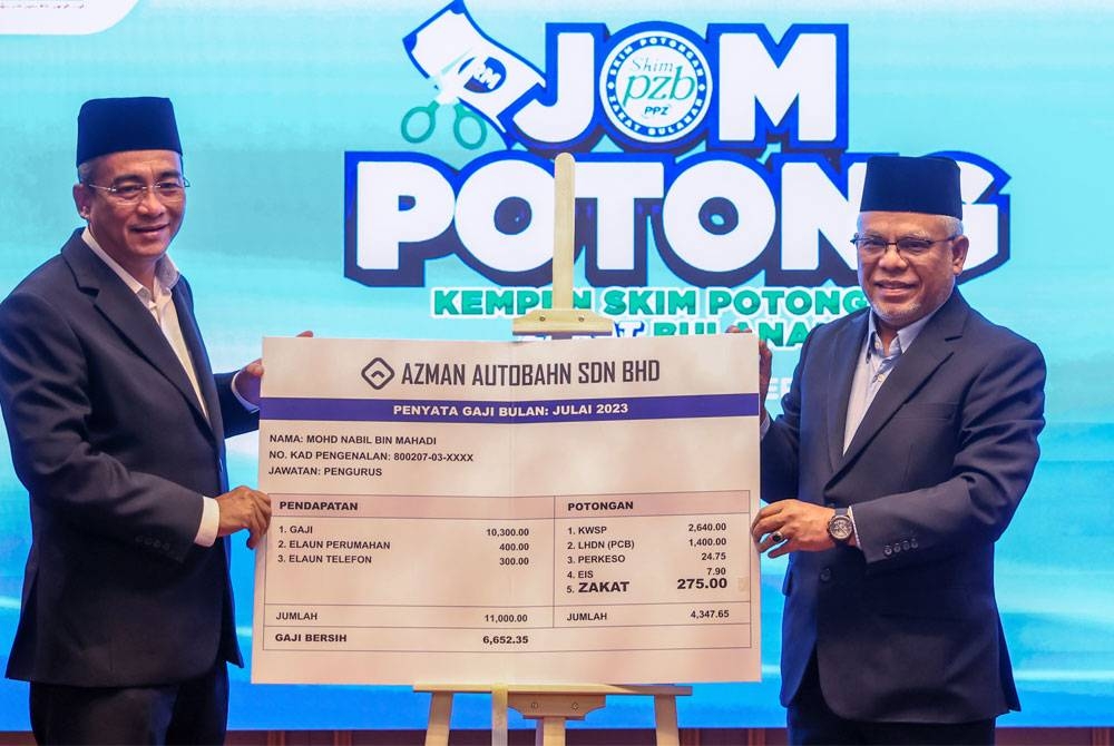 Abdul Hakim (kanan) bersama Timbalan Ketua Pegawai Eksekutif (operasi) PPZ, Mohamed Hassan (kiri) menunjukkan slip gaji sebagai gimik pelancaran Kempen Skim Potongan Zakat Bulanan 2023, pada Isnin. - Foto Bernama