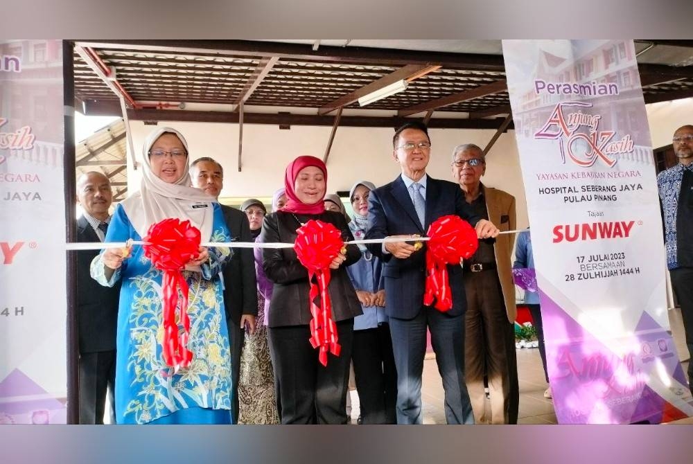 Dr Zaliha (kiri), Nancy (tengah) dan Jeffrey (kanan) memotong reben simbolik pembukaan Anjung Kasih Hospital Seberang Jaya, pada Isnin.