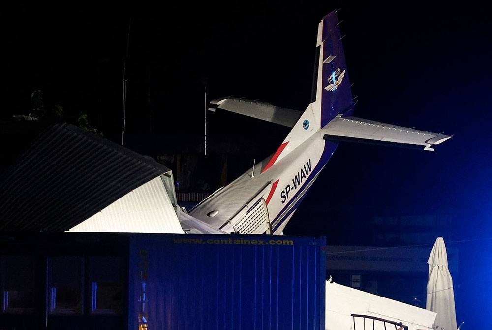 Sebuah pesawat Cessna melanggar hangar lapangan terbang di Poland pada Isnin. - Foto AFP