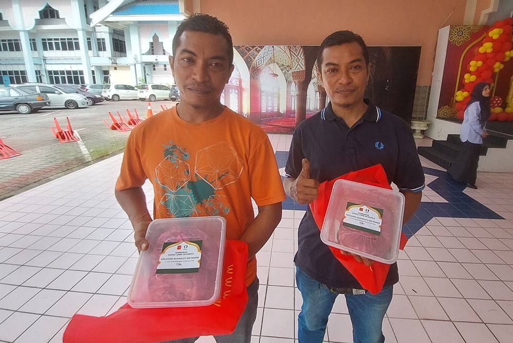 Mohd Azli (kiri) dan Mohd Azlan menerima sumbangan daging daripada McDonald&#039;s Malaysia pada Majlis Penyerahan Zakat Perniagaan dan Sumbangan Lembu oleh McDonald&#039;s Malaysia kepada asnaf zakat negeri Terengganu pada Isnin.